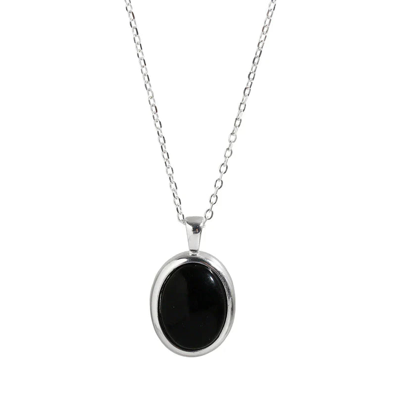 Silberkette mit ovalem schwarzem Anhänger, eleganter Schmuck, Damenaccessoire.