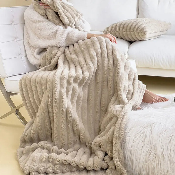 Flauschige beige Decke aus Kunstfell, gestreift, auf Sofa, gemütlich, Wohnzimmer-Dekoration.