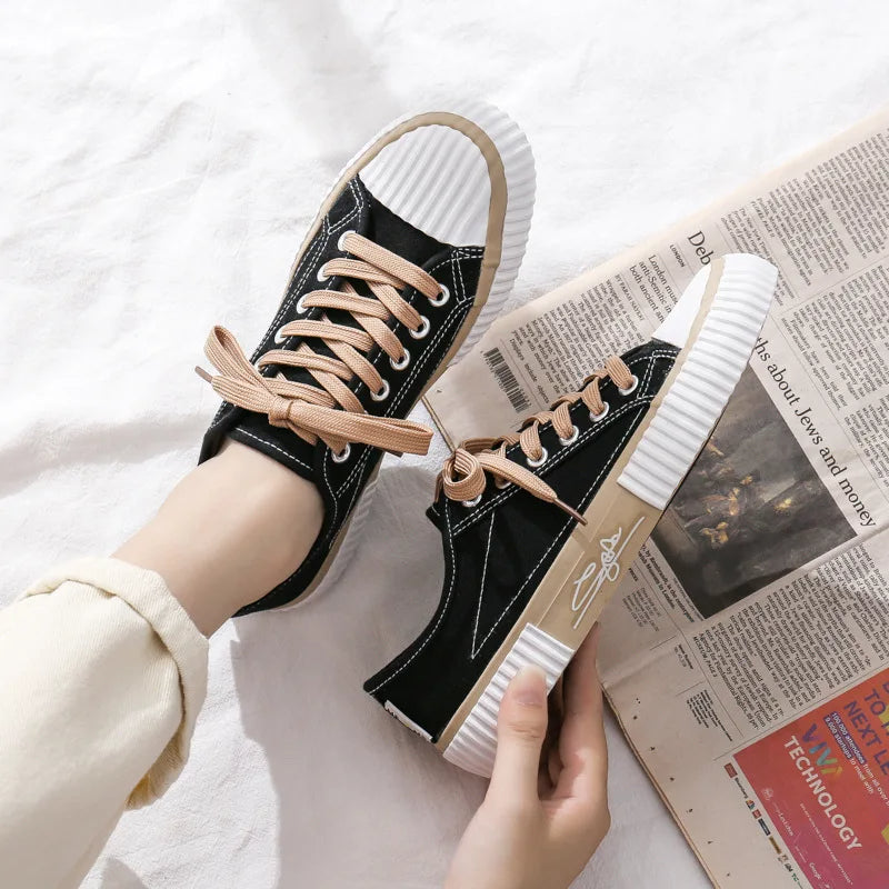 Schwarze Canvas-Sneaker mit beigen Schnürsenkeln, weißer Sohle, lässiger Stil, Damenmode.