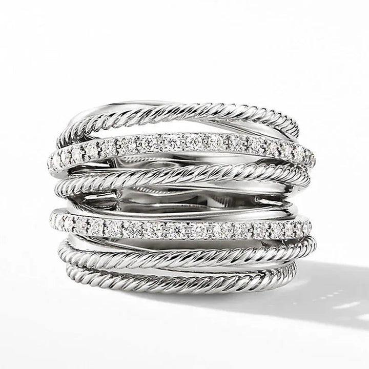 Silberring mit mehreren verdrehten Bändern und funkelnden Kristallen, elegantes Schmuckdesign.