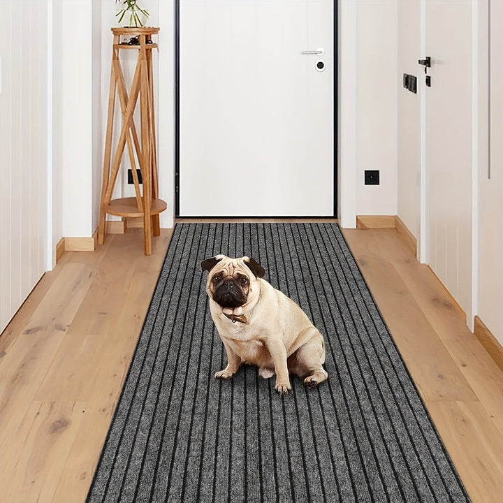Mops auf grauem Läufer im Flur, Holzboden, weiße Wände, moderne Einrichtung.