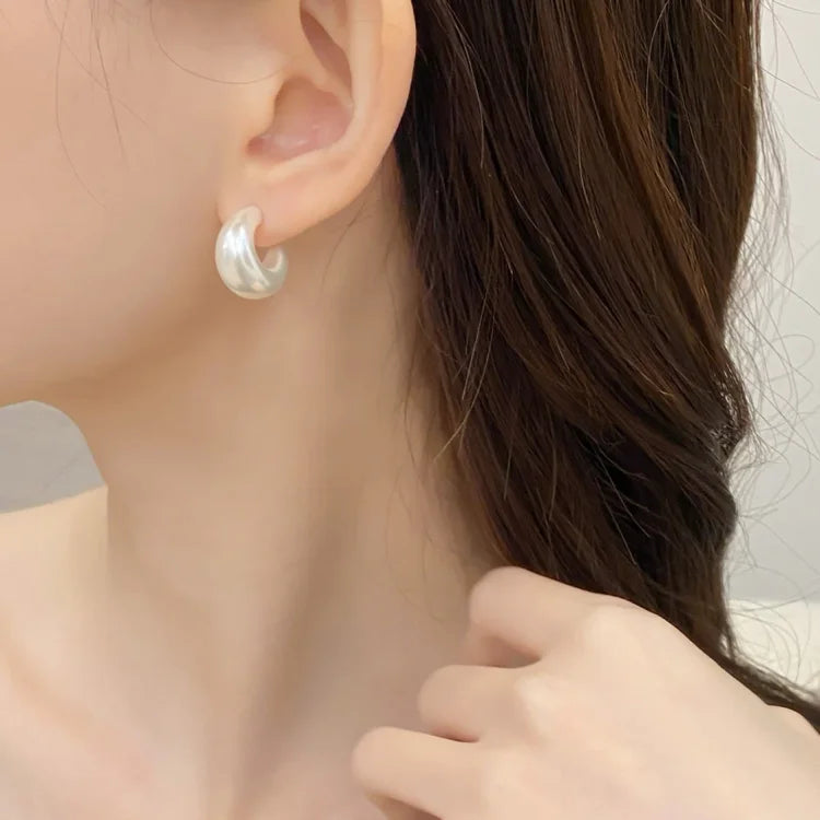 Ohrring aus Silber an Frauenohr, elegantes Schmuckdesign, modisches Accessoire.