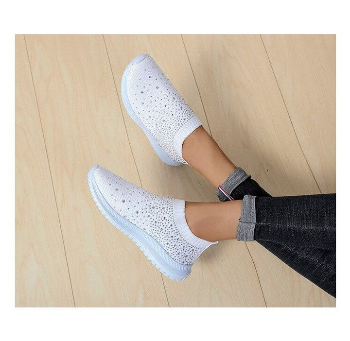 Weiße Damen-Sneaker mit Strass, atmungsaktiv, rutschfest, bequem, modisch, auf Holzfußboden.