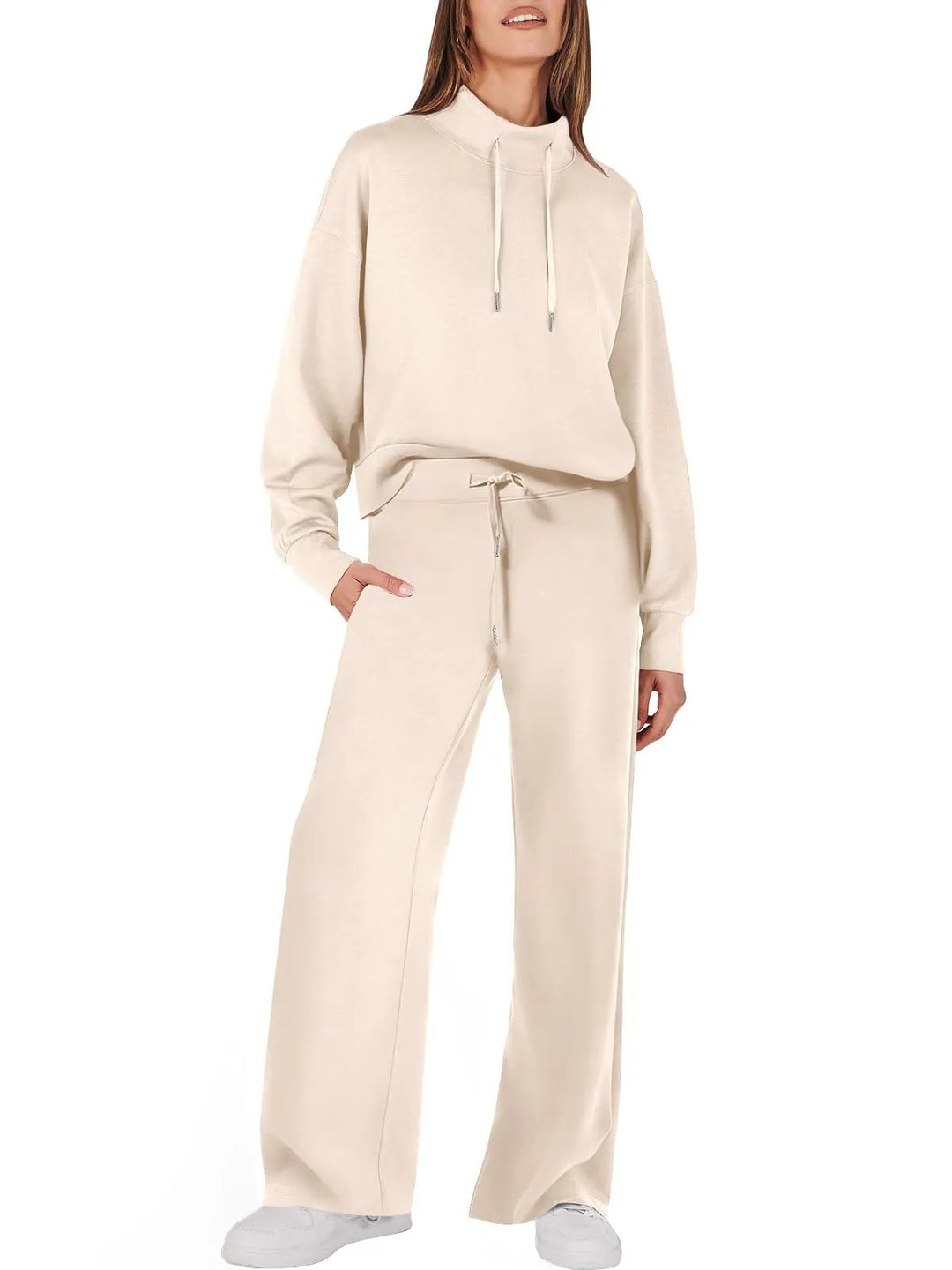 Frau in cremefarbenem Damenanzug, Kapuzenpullover und Hose, Freizeitmode, bequemes Outfit.