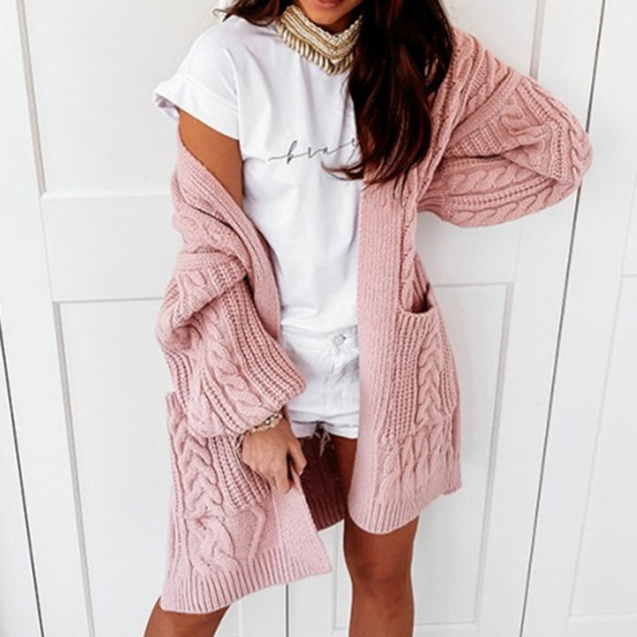 Frau trägt rosa Strickjacke, weißes T-Shirt, Shorts; modische Damenbekleidung, lässiger Look.