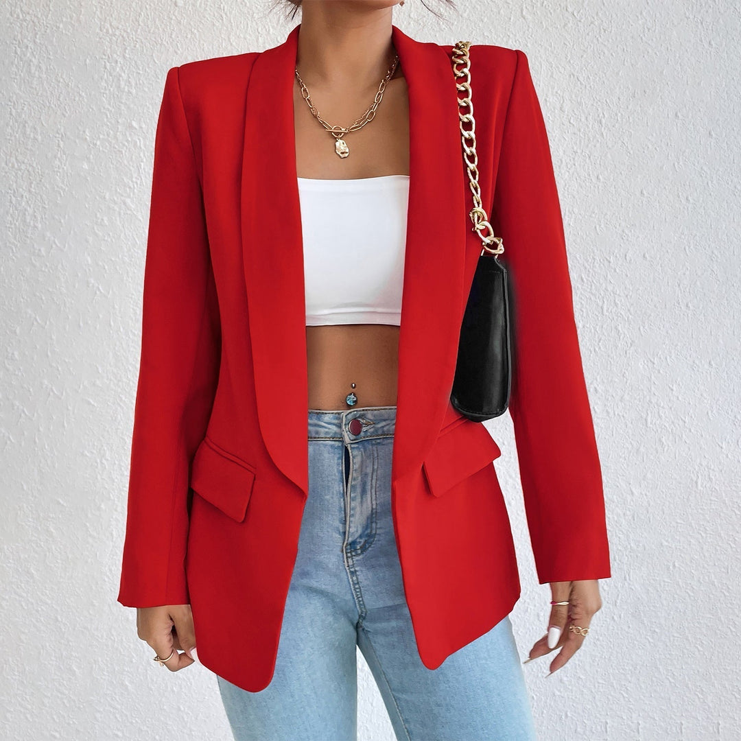 Frau in rotem Blazer, weißem Top, blauer Jeans, schwarze Tasche, modisch, elegant.