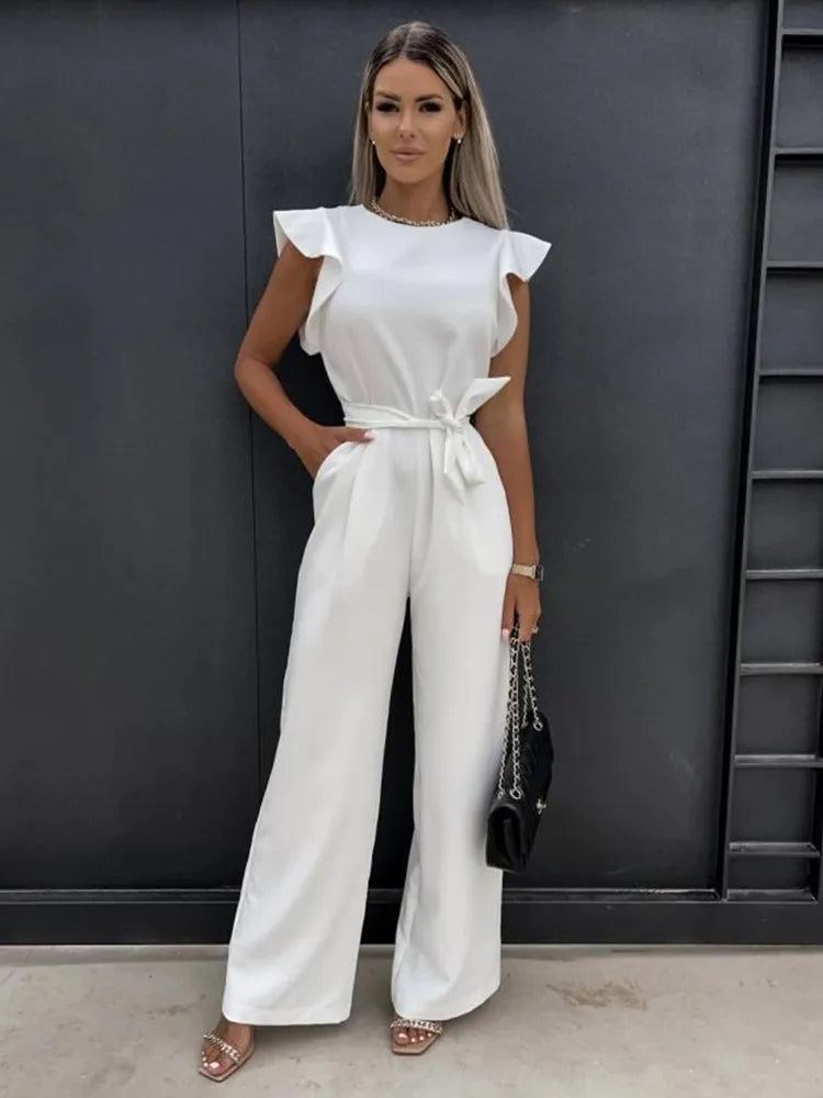 Frau in weißem Jumpsuit mit Schmetterlingsärmeln, elegantes Sommeroutfit, Vintage-Streetwear.
