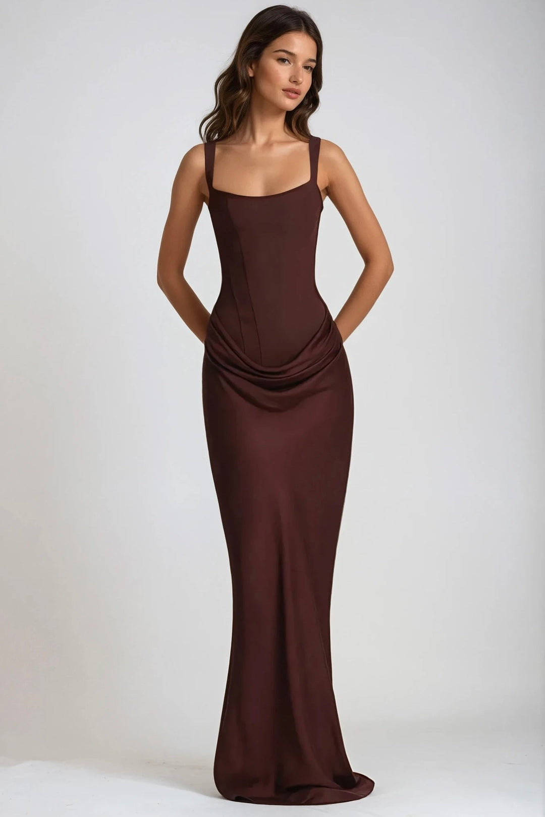 Tmavě hnědé přiléhavé maxi šaty s řasením, modelka stojí zepředu s rukama za zády 8
