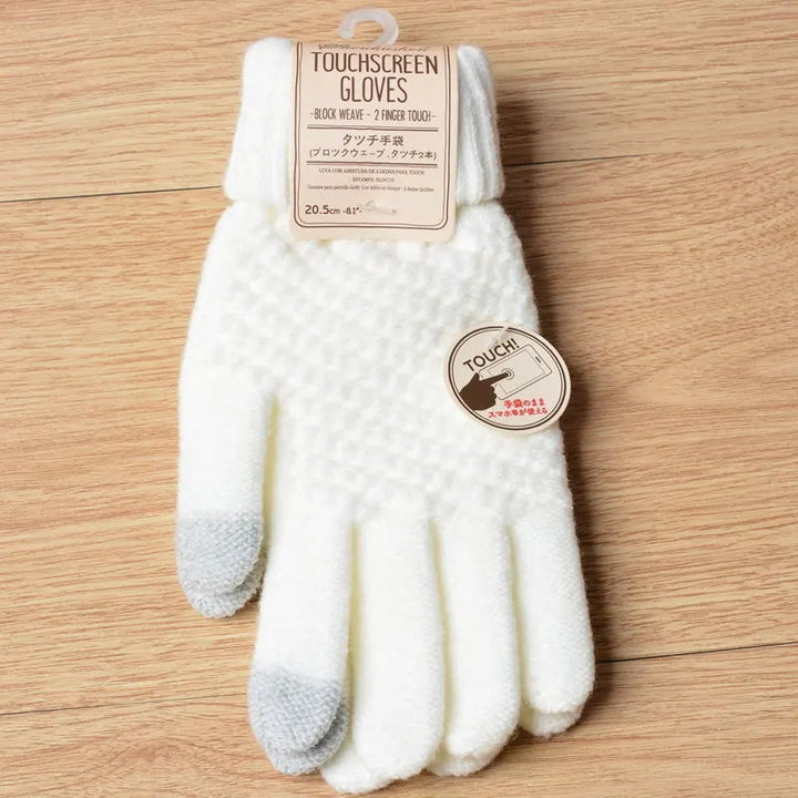 Weiße Touchscreen-Handschuhe, gestrickt, mit grauen Fingerspitzen, auf Holzoberfläche.