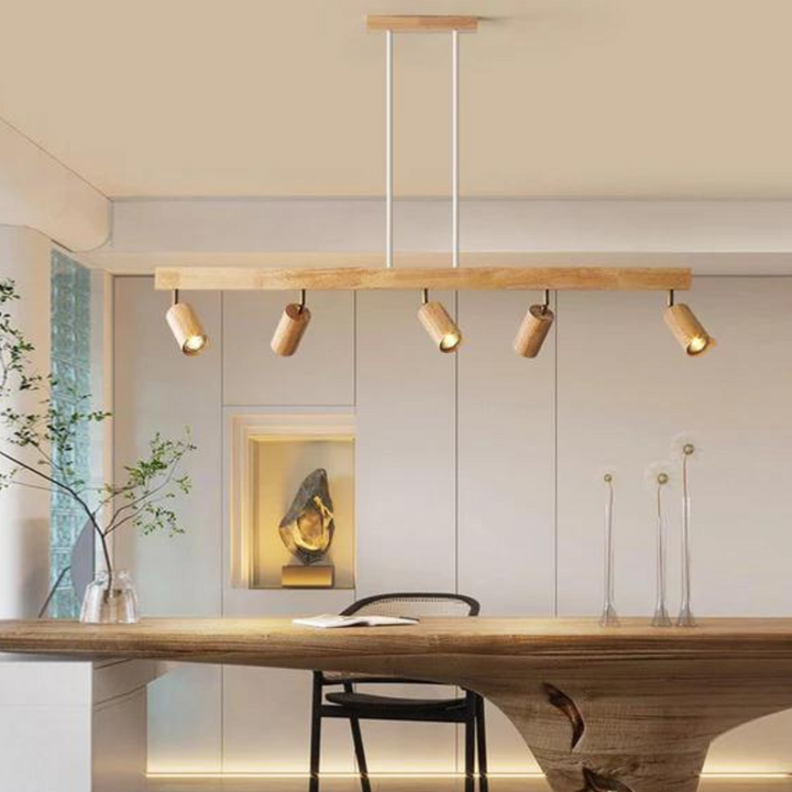 Moderne Holz-Pendelleuchte mit fünf verstellbaren Spots über Esstisch im minimalistischen Raum.
