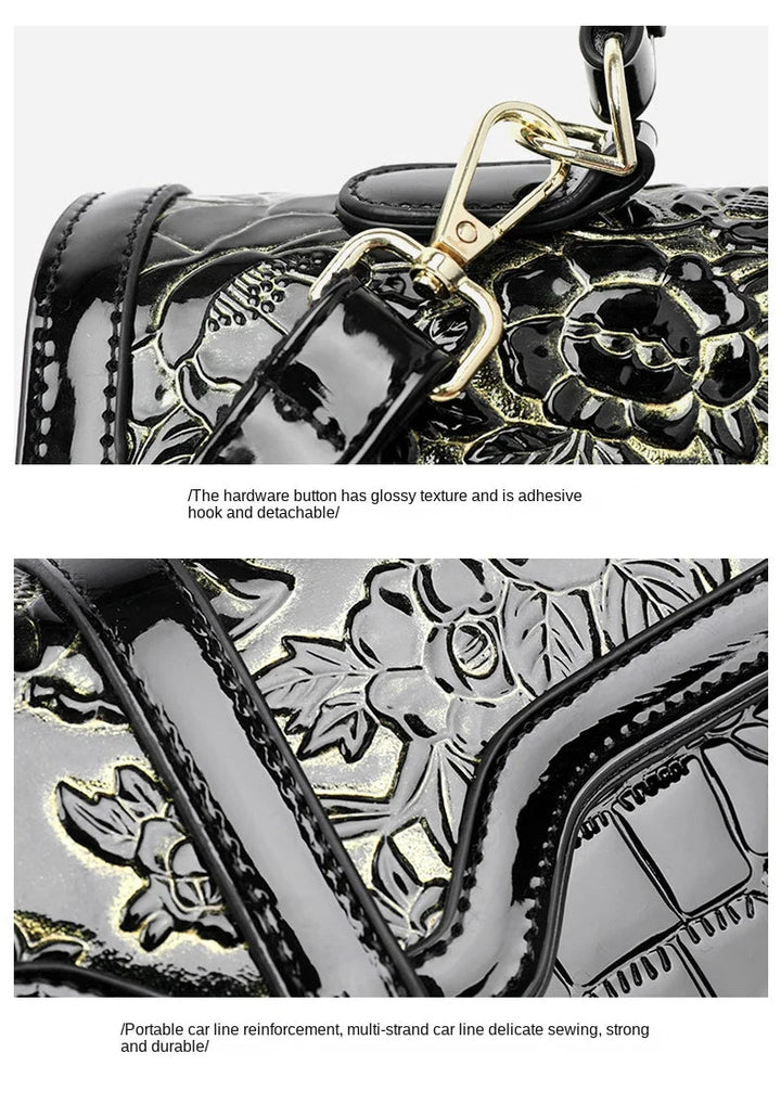 Schwarze Lederhandtasche mit glänzendem Blumenmuster und abnehmbarem goldfarbenem Haken.