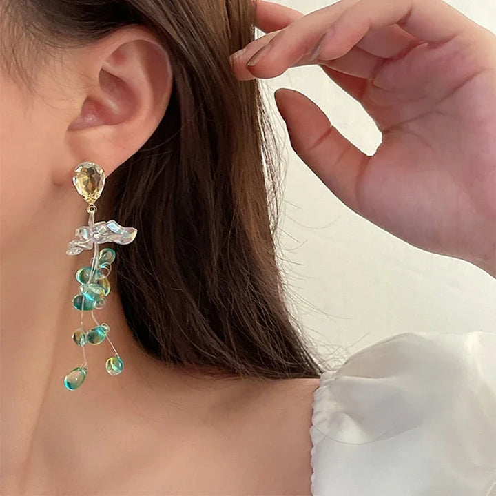 Frau mit eleganten Ohrringen aus Kristall und Perlen, modisches Accessoire, Nahaufnahme.