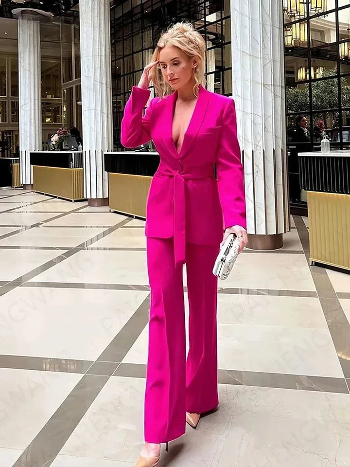Frau in pinkem Blazer mit Gürtel und passender Hose, elegantes Outfit, moderne Mode.
