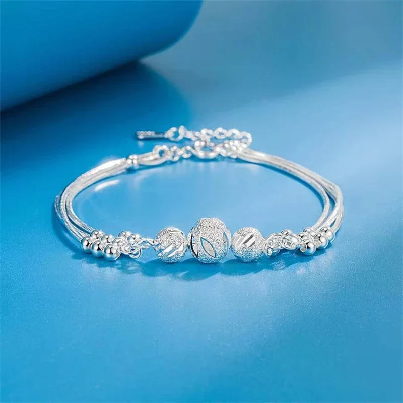 Silberarmband mit Kugelanhängern, elegantes Design, Damen-Schmuck, Geschenkidee, modisch.