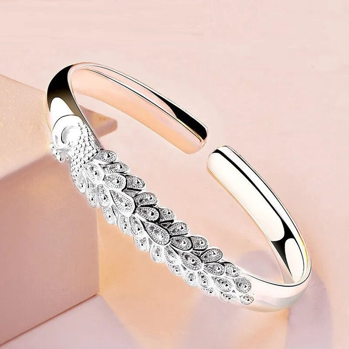 Silberner Armreif mit Pfauenmotiv, elegantes Design, Schmuck für Damen, Geschenkidee.