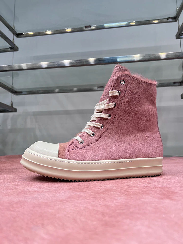 Rosa High-Top-Sneaker aus Leder mit weißer Sohle und Schnürsenkeln auf rosa Hintergrund.