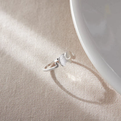 Silberner Elefantenring auf beigem Stoff, elegantes Schmuckdesign, Geschenkidee für Tierliebhaber.