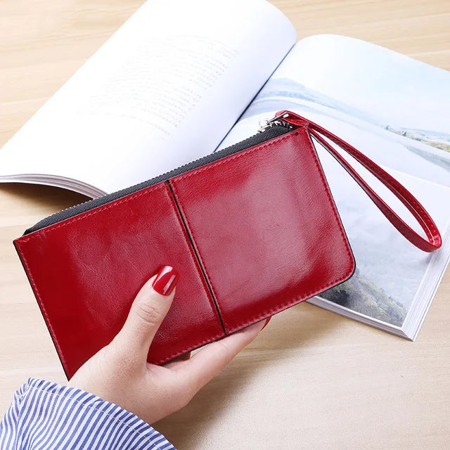 Rote Lederhandtasche mit Reißverschluss, Damenmode, elegantes Design, auf Holztisch.