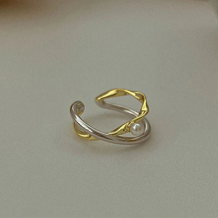 Silberner und goldener offener Ring mit Perle, eleganter Schmuck, modisches Accessoire.