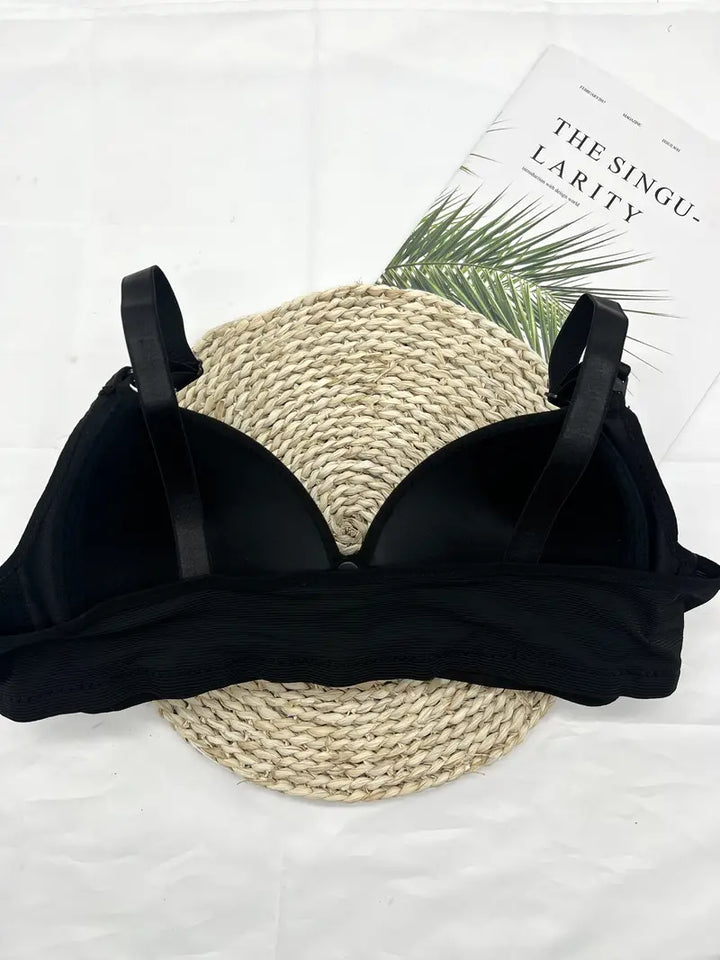 Schwarzer BH aus Spitze auf weißem Hintergrund, elegantes Dessous, Damenunterwäsche.