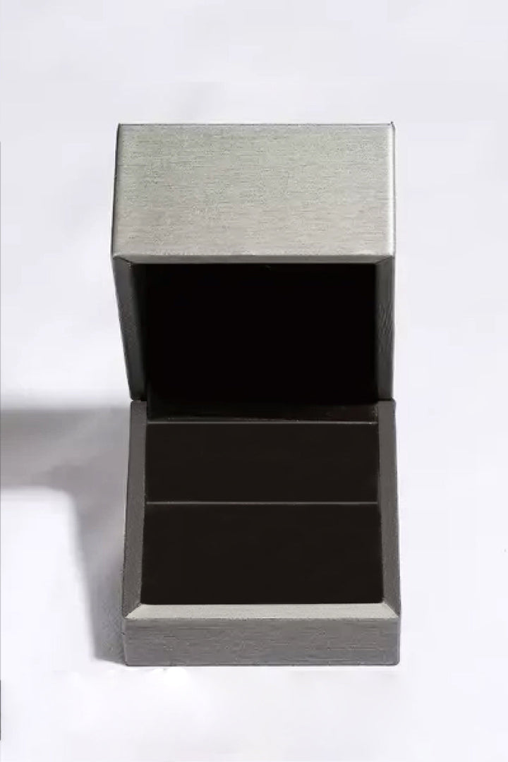 Leere silberne Schmuckschatulle, quadratisch, offen, aus Metall, auf weißem Hintergrund.