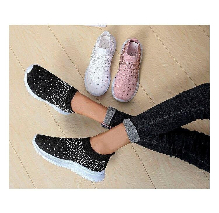 Schwarze Damen-Sneaker mit Strass, rutschfest, bequem, modisch, auf Holzboden.