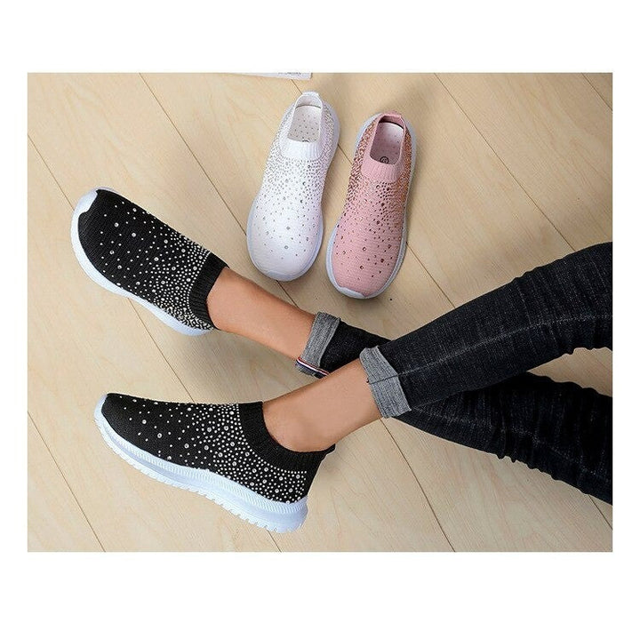 Schwarze Damen-Sneaker mit Strass, rutschfest, bequem, modisch, auf Holzboden.