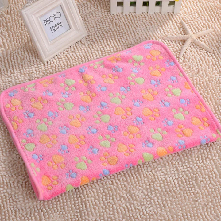 Rosa Fleece-Haustierdecke mit bunten Pfotenabdrücken, weich und warm für Katzen und Hunde.