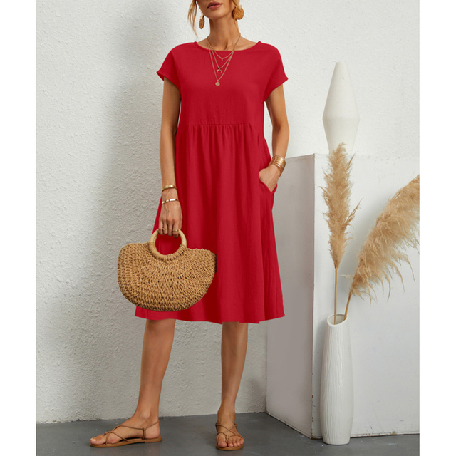Frau in rotem Baumwollkleid, A-Linie, mit Strohtasche, Sommermode, Boho-Stil.