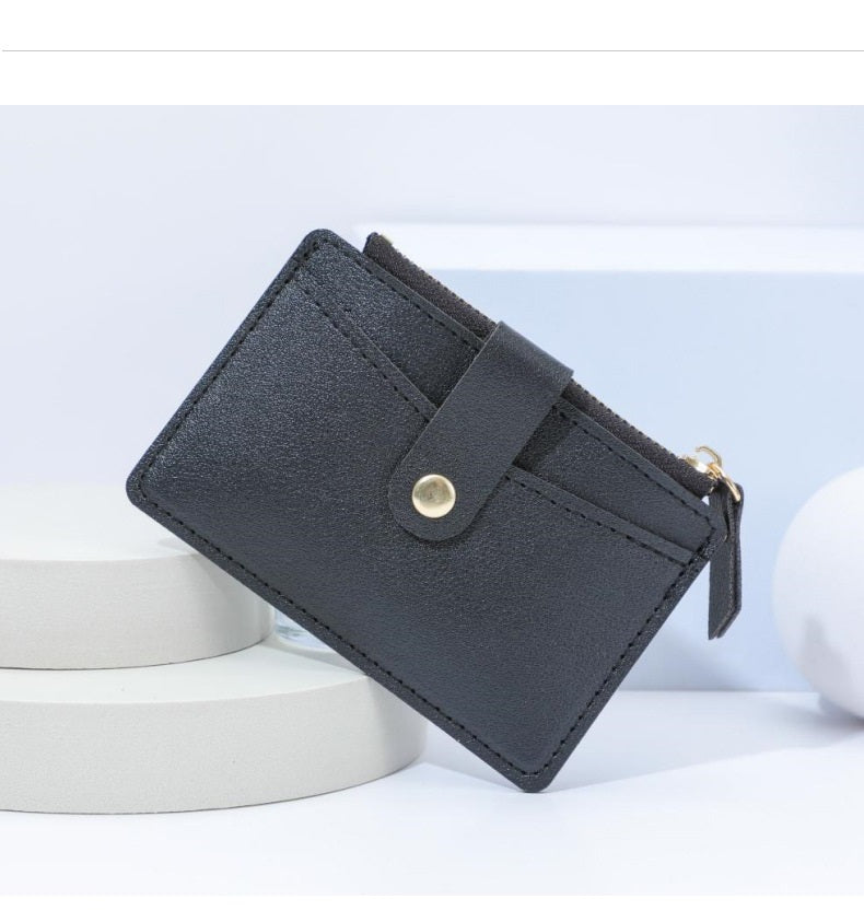 Schwarzes Leder-Kartenetui mit Druckknopf, minimalistisches Design, stilvoll und praktisch.
