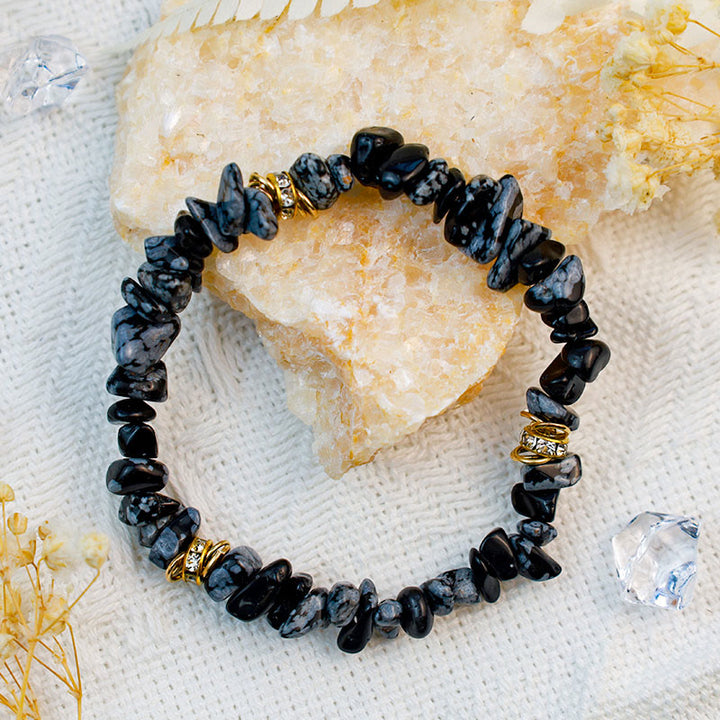 Armband aus schwarzem Obsidian mit goldenen Akzenten, handgefertigt, auf hellem Hintergrund.