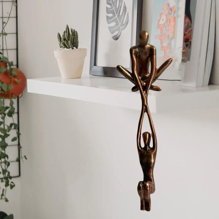 Bronzeskulptur von zwei Figuren, moderne Kunst, auf weißem Regal, dekorative Wohnaccessoires.
