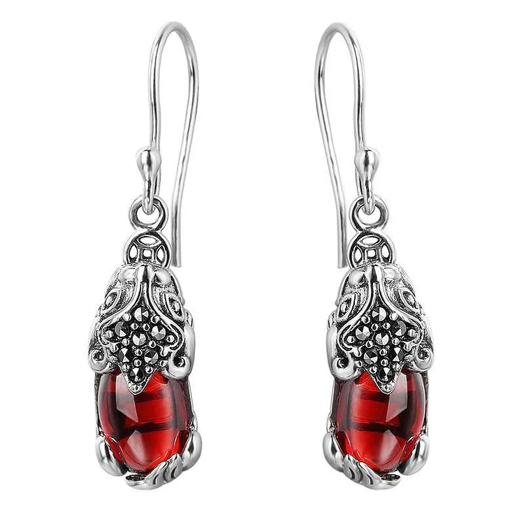 Silberne Ohrringe mit roten Edelsteinen, filigranes Design, Schmuck für Damen, elegant und stilvoll.