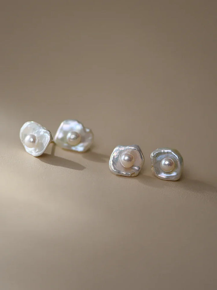 Perlenohrringe aus Silber mit unregelmäßiger Form auf beigem Hintergrund, eleganter Schmuck.