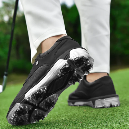 Schwarze Golfschuhe mit Spikes auf grünem Rasen, Golfschläger im Hintergrund.