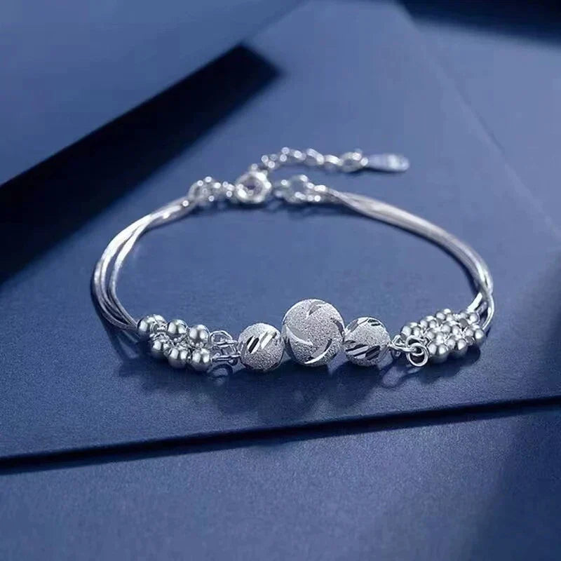 Silberarmband mit Kugelanhängern, elegantes Design, Schmuck für Damen, Geschenkidee.