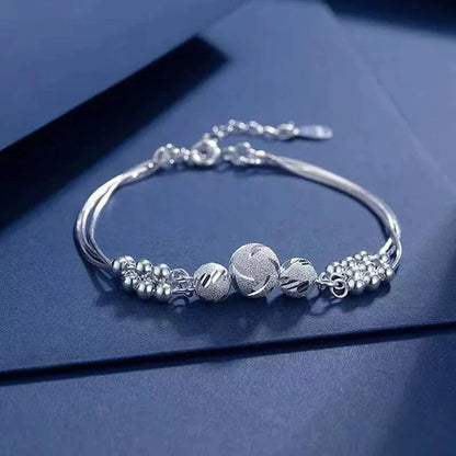 Silberarmband mit Kugelanhängern, elegantes Design, Schmuck für Damen, Geschenkidee.