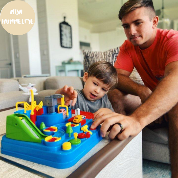 Erwachsener und Kind spielen mit buntem Spielzeugset auf Tisch im Wohnzimmer.