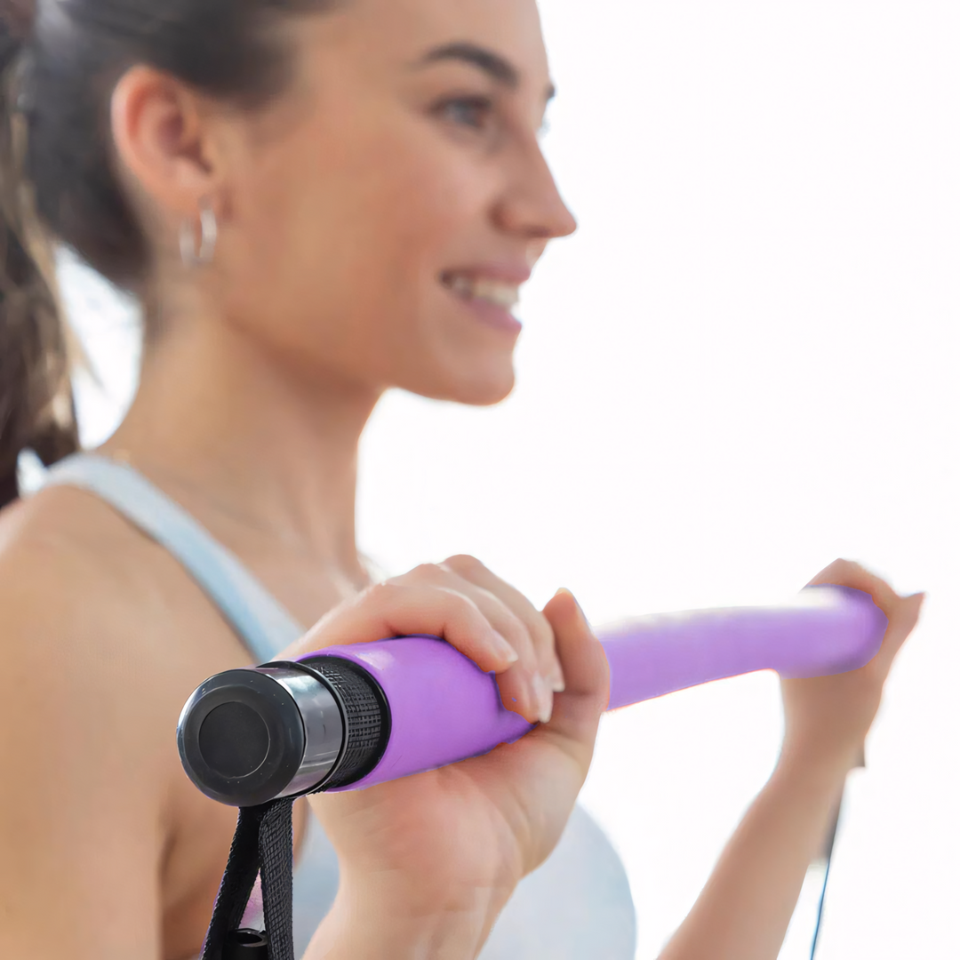 Frau trainiert mit lila Springseil, Fitness, Sportgerät, Heimtraining, Ausdauer, Workout.