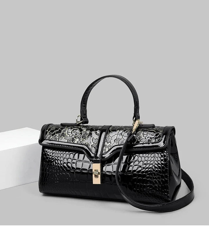 Schwarze Damenhandtasche aus Leder mit Krokodilprägung und Blumenmuster, elegant und stilvoll.
