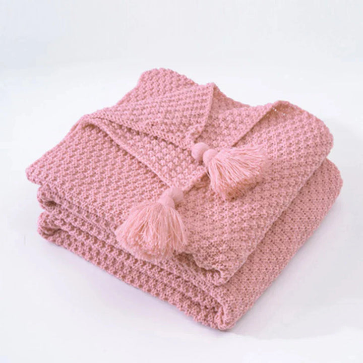 Rosa gestrickte Decke mit Quasten, weiches Baumwollmaterial, gemütliche Wohnaccessoires.