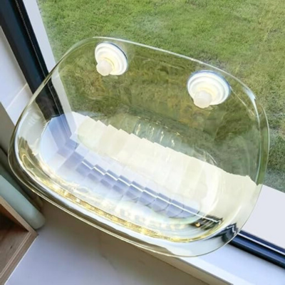 Transparenter Vogelfutterspender aus Kunststoff am Fenster befestigt, ideal für Vogelbeobachtung.