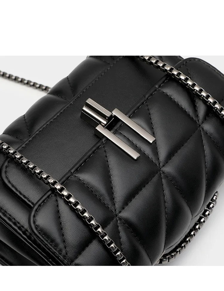Schwarze gesteppte Ledertasche mit Kettenriemen und silbernem Verschluss.