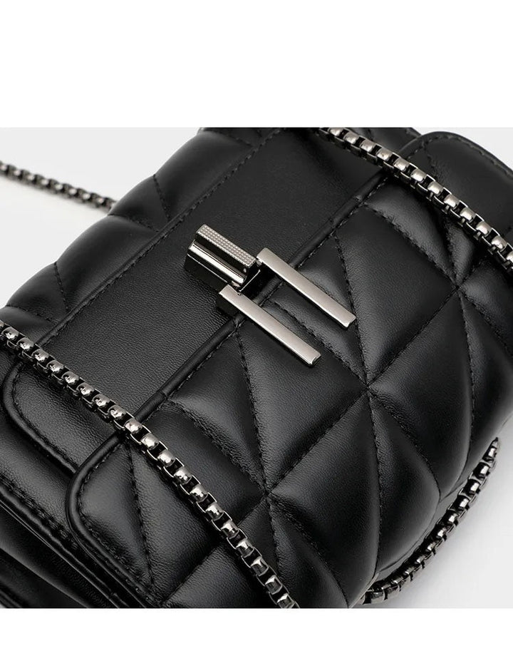 Schwarze gesteppte Ledertasche mit Kettenriemen und silbernem Verschluss.