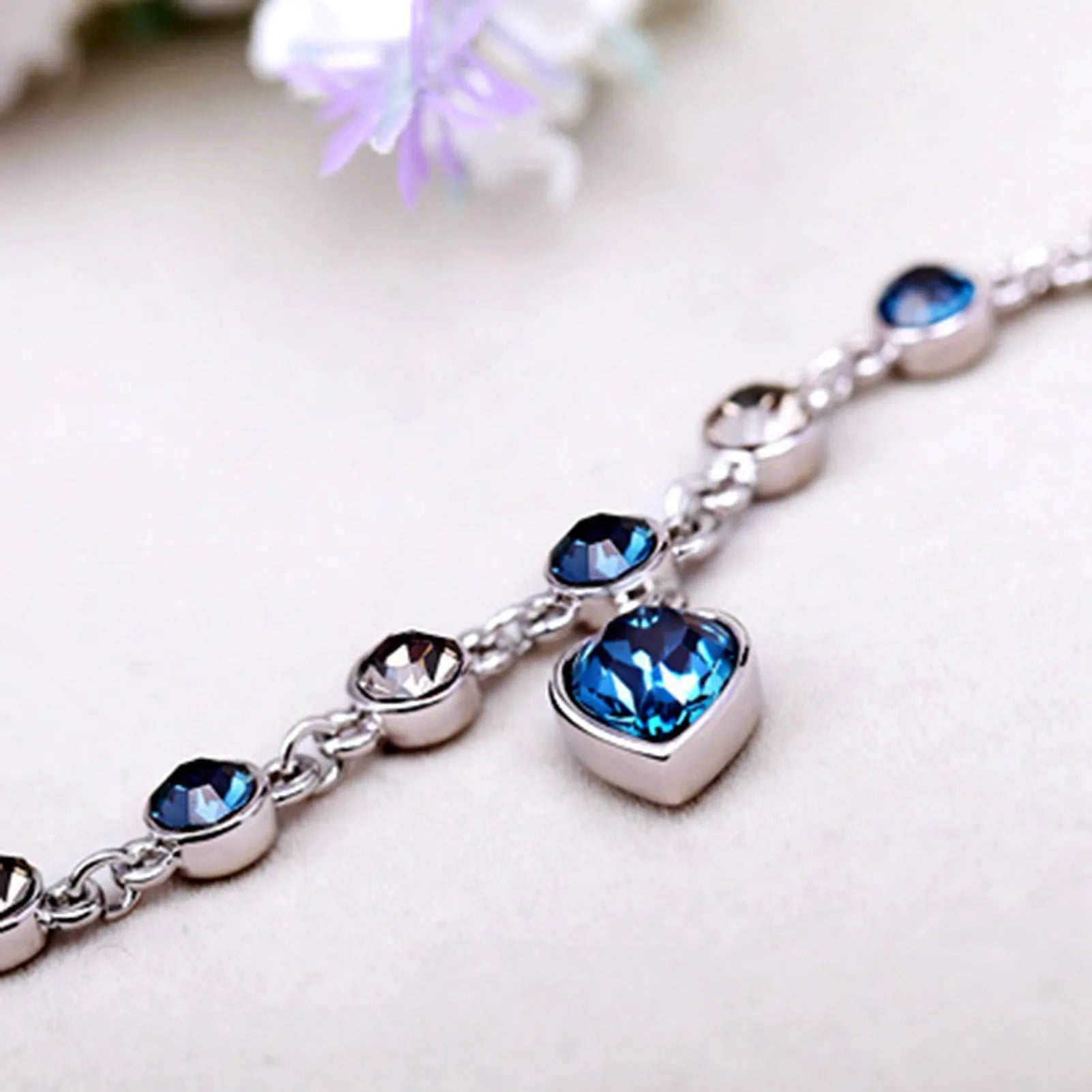 Silberarmband mit blauen Kristallen, Herzanhänger, eleganter Schmuck für Damen.