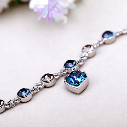 Silberarmband mit blauen Kristallen, Herzanhänger, eleganter Schmuck für Damen.