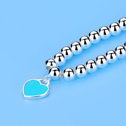 Silberne Perlenkette mit blauem Herzanhänger, Schmuck, modisch, elegant, Damenaccessoire.