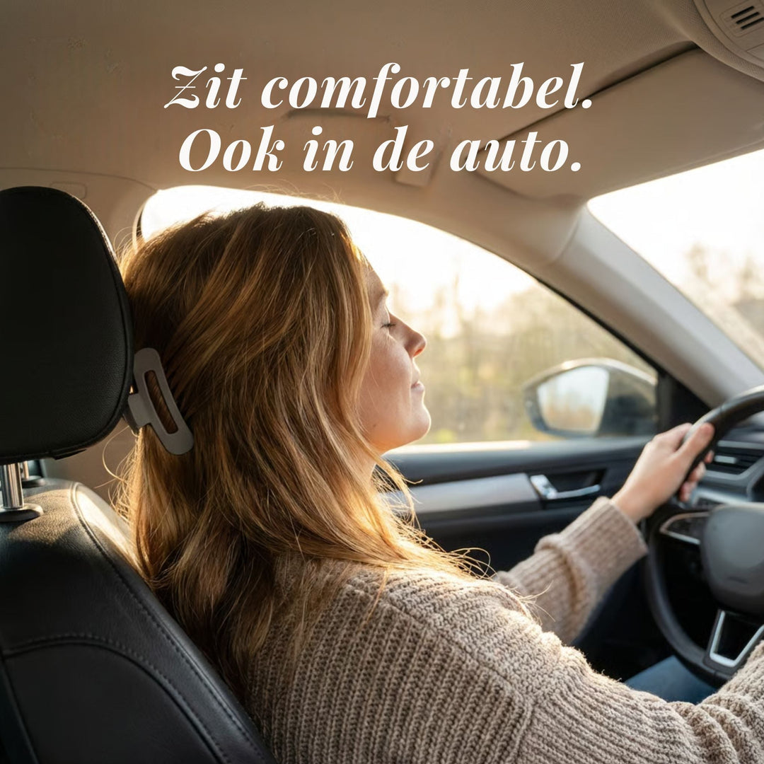 Žena s hnědými vlasy sepnutými šedou sponkou řídí auto a opírá se o opěrku hlavy 2