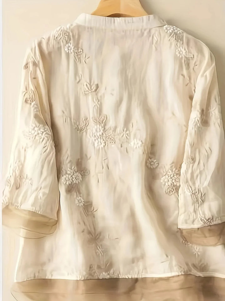 Beige Damenbluse mit floraler Stickerei, 3/4-Ärmel, elegantes Design, aus Baumwolle.
