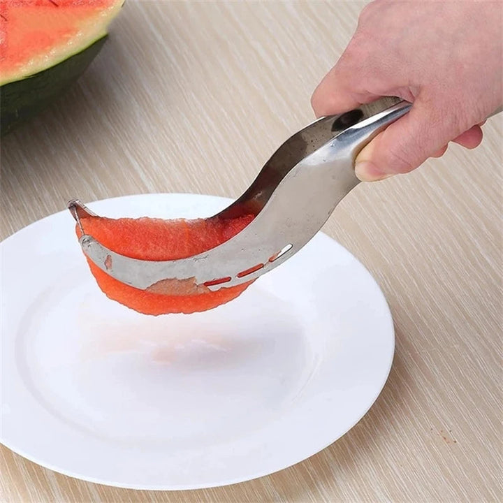 Wassermelonen-Schneider aus Edelstahl, handgehalten, schneidet Fruchtfleisch auf weißem Teller.